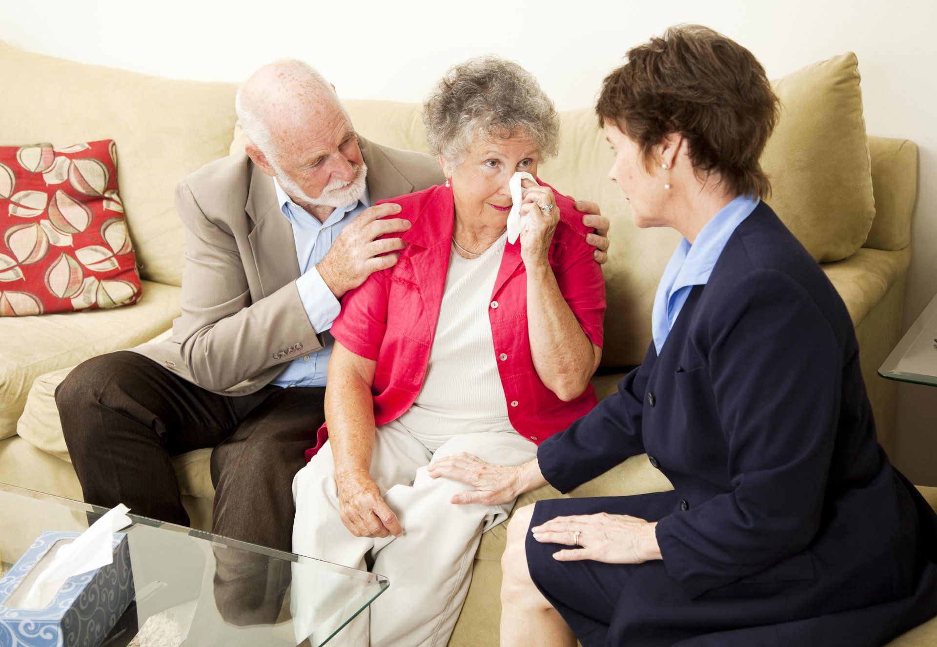couple crying on couch while talking to funeral director