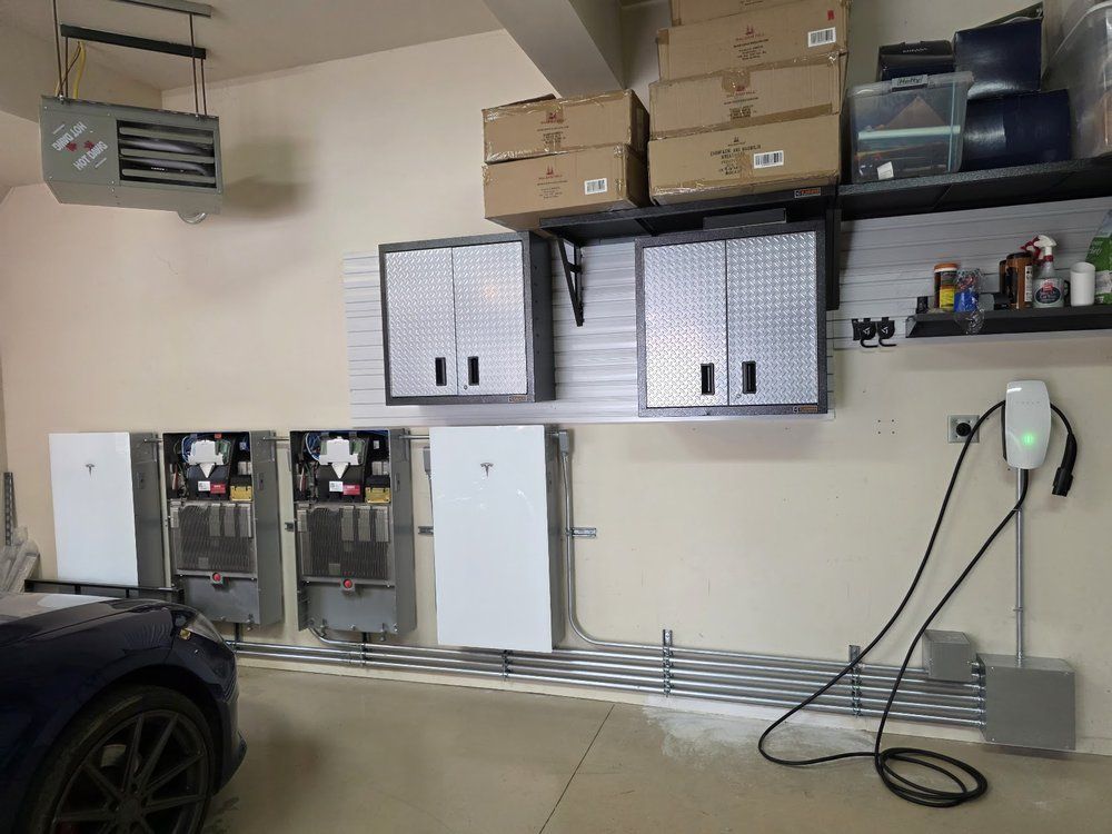 Garage wall with electrical panels, boxes on shelves, and a black car partially visible on the left.