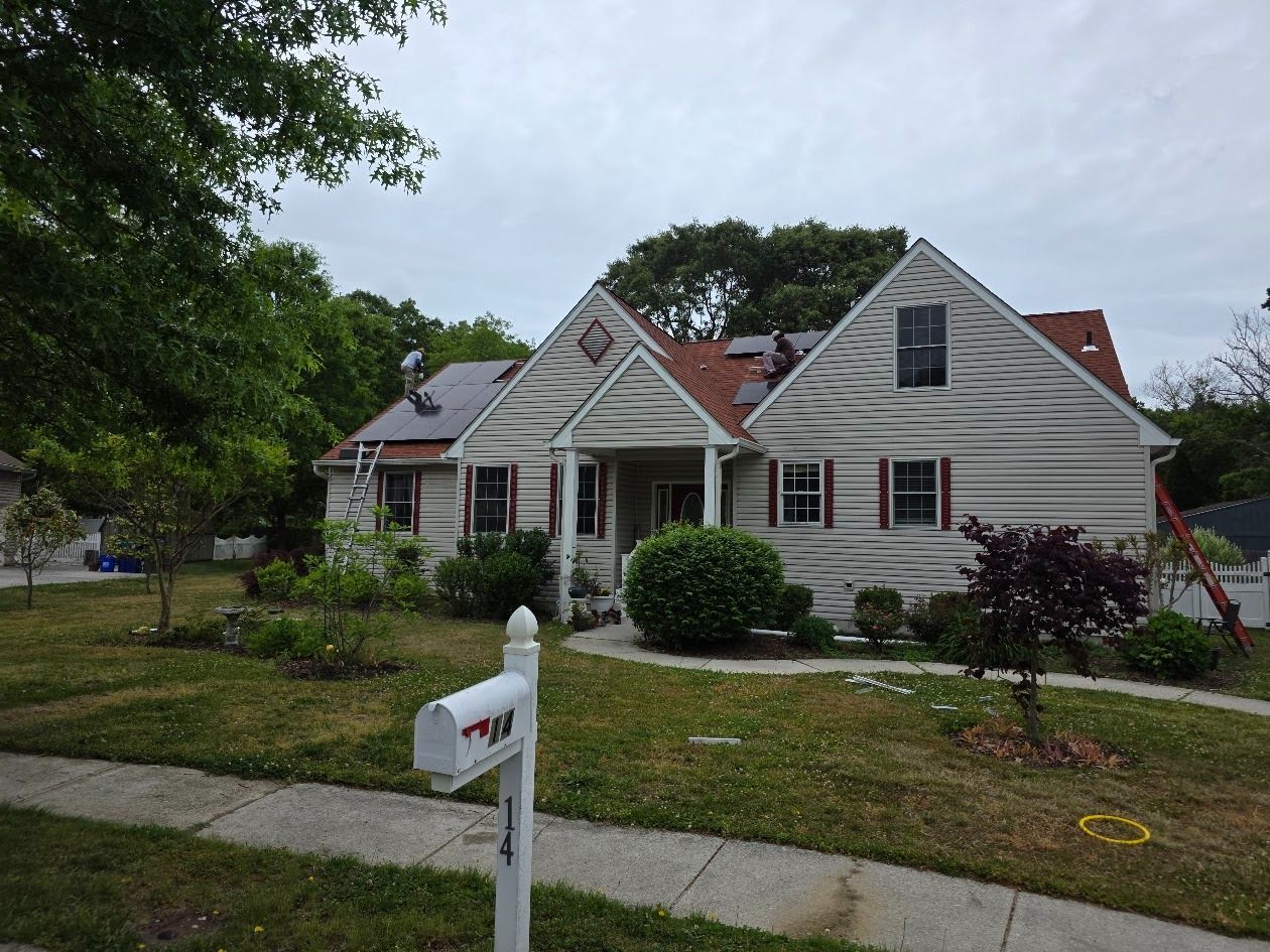 Small white house with a front lawn, sidewalk, and a white mailbox under a cloudy sky