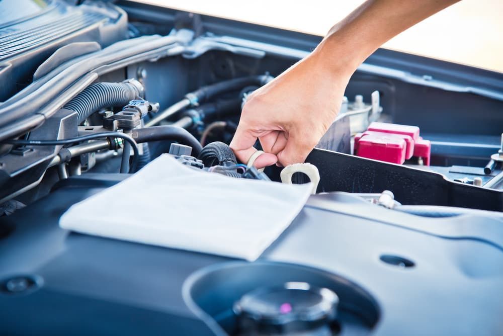 A Person Is Cleaning the Engine of A Car with A Towel — Andy's A1 Auto Care in Barrack Heights, NSW