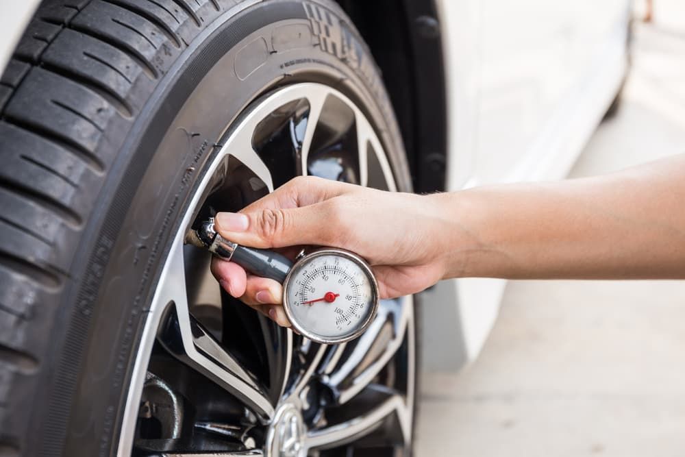 A Person Is Checking the Pressure of A Tire with A Gauge — Andy's A1 Auto Care in Barrack Heights, NSW
