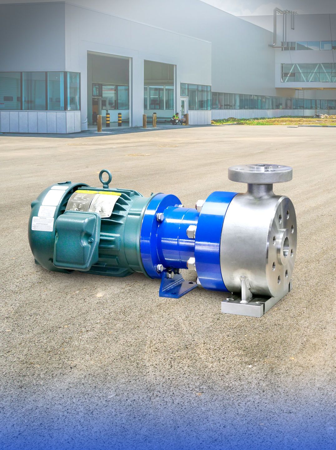 A blue and silver industrial pump with a green motor, outside a building.
