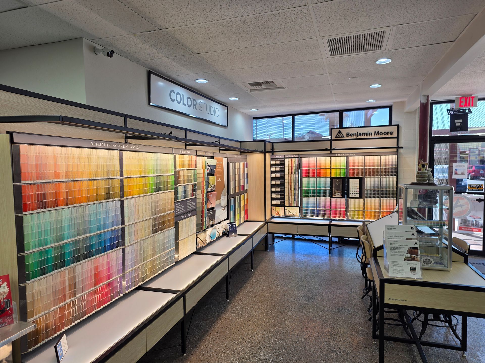 Art supply store aisle with paint samples, shelves of supplies, and a display of brushes and canvas sets