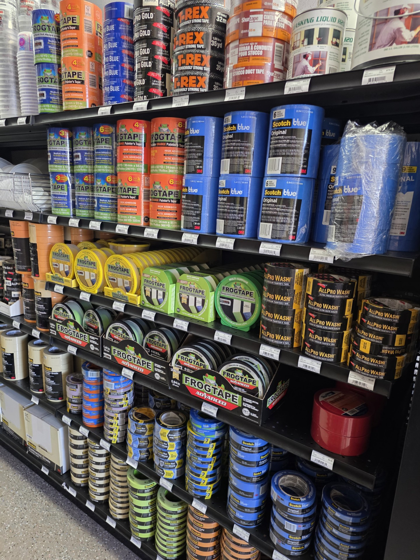 Paint cans and supplies displayed on shelves in a hardware store aisle