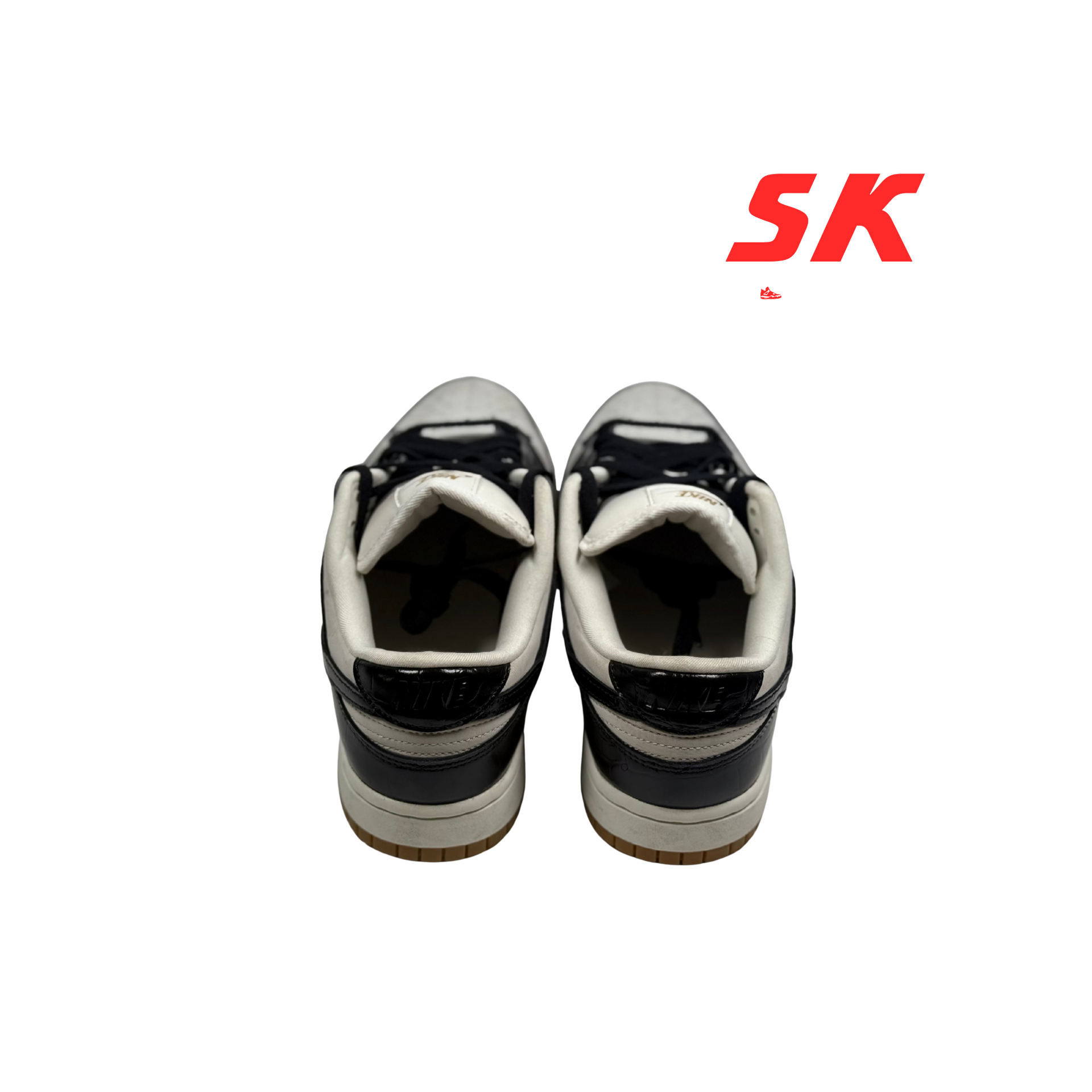 A pair of black and white Nike Dunk Low sneakers with black laces, viewed from the front.