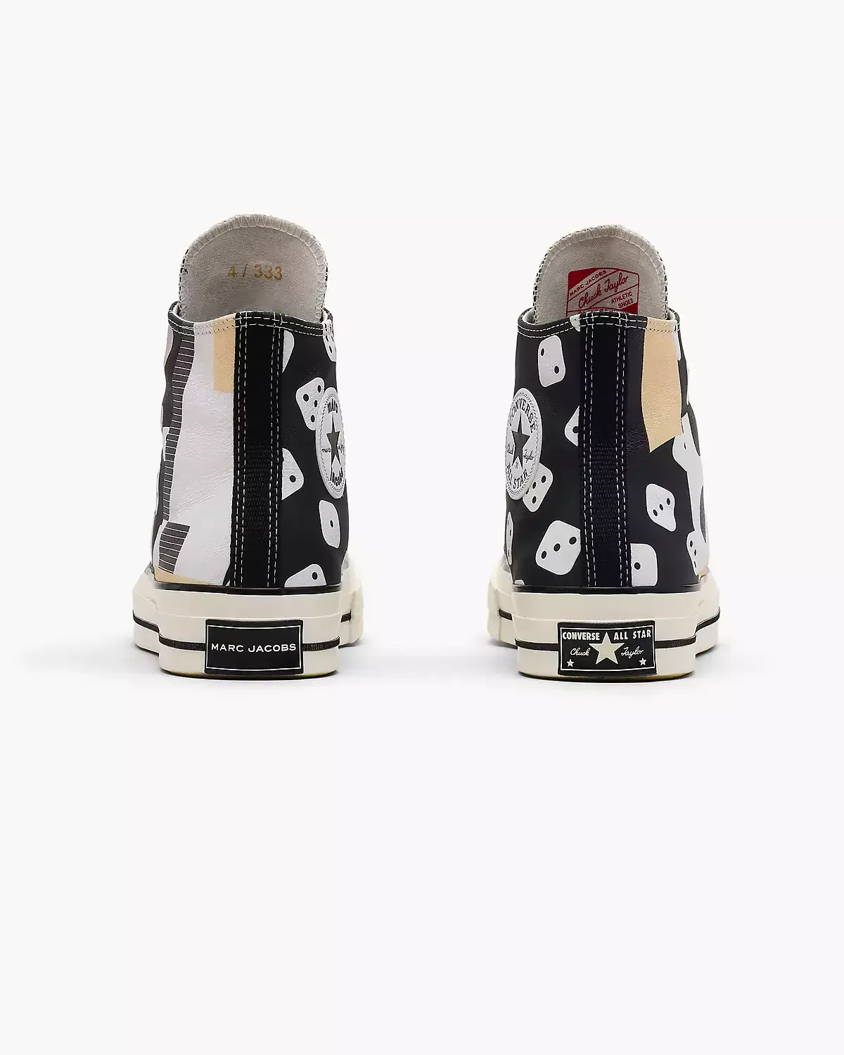 Two high-top Converse sneakers with a black and white spotted pattern, viewed from the back.