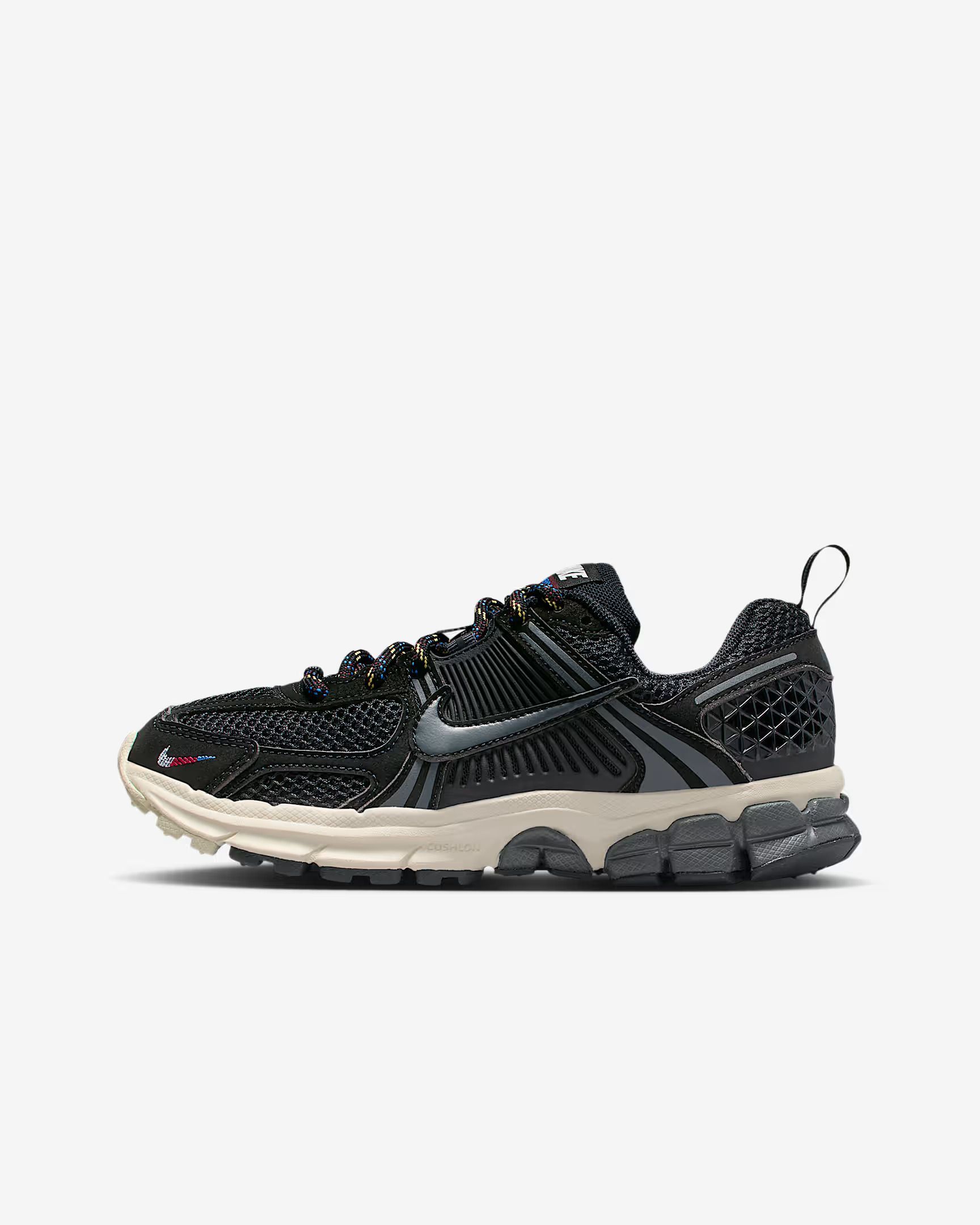Black and gray Nike sneaker with patterned upper, beige sole, and dark gray accents.