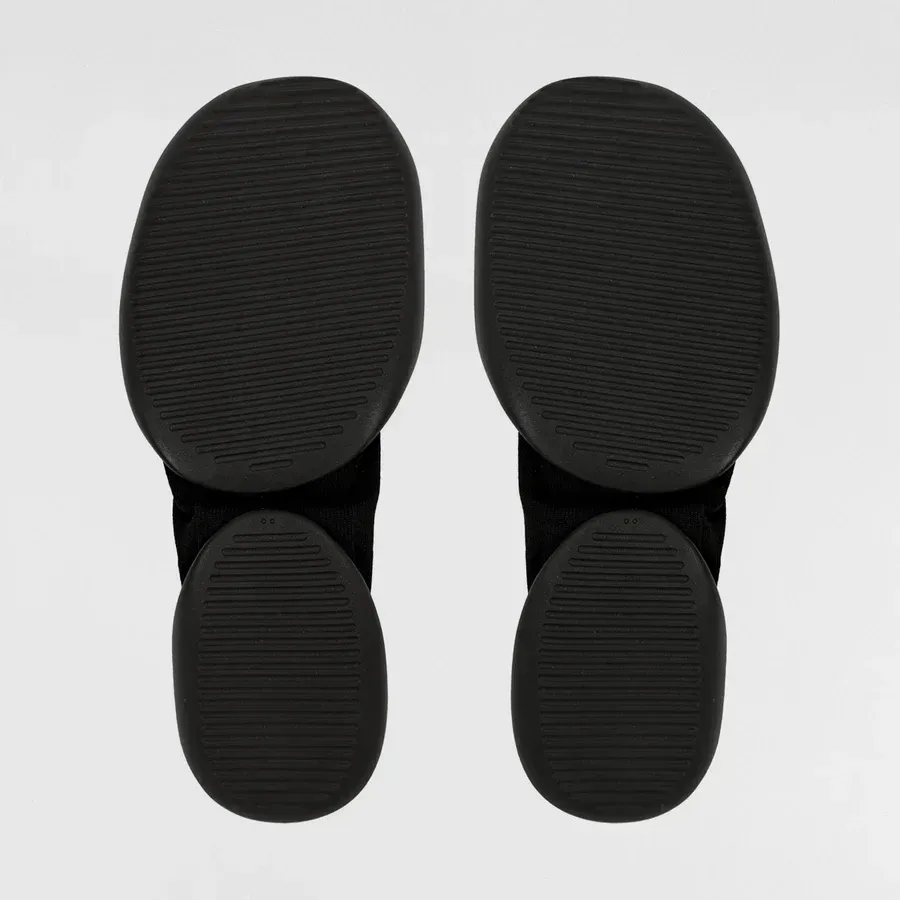Two black knee-high socks, standing upright against a light gray background.