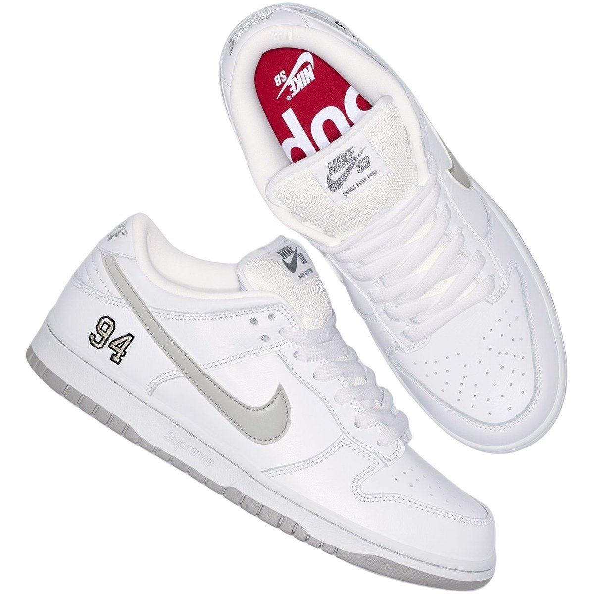 White and gray Nike SB Dunk Low sneakers, with