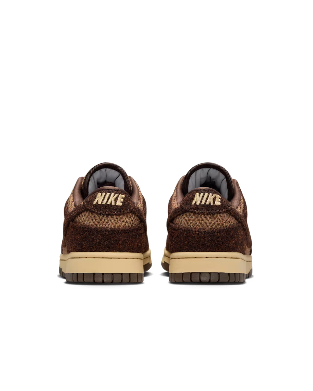 Two Nike Dunk sneakers from the back, brown fuzzy uppers, beige soles, and