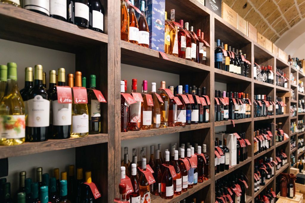 Bottiglie di vino esposte sugli scaffali in una corsia di un negozio.
