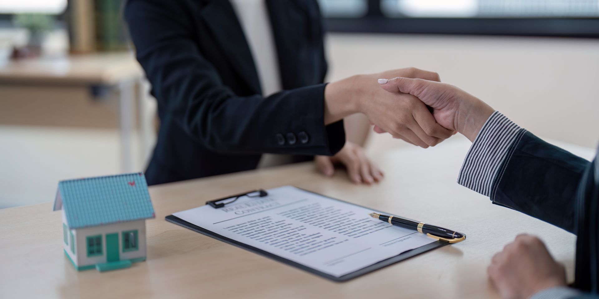 A lawyer is shaking hands with a client in front of a scale of justice