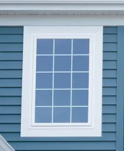 White-trimmed window with white grid panes on a blue house exterior siding.