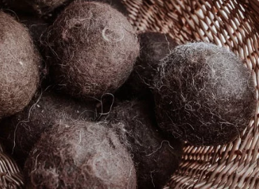 Brown, wool dryer balls in a woven basket.