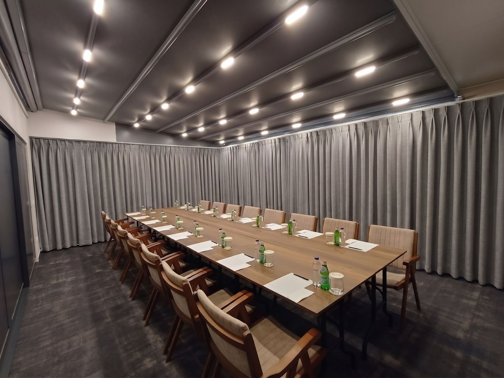 Izz Hotel Koşuyolu | İstanbul | Long conference table set in a gray curtained meeting room with chairs and water bottles