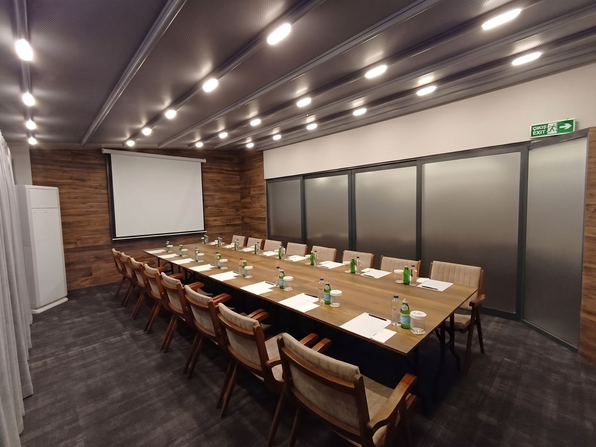 Izz Hotel Koşuyolu | İstanbul |Empty modern conference room with long wooden table, chairs, projector screen