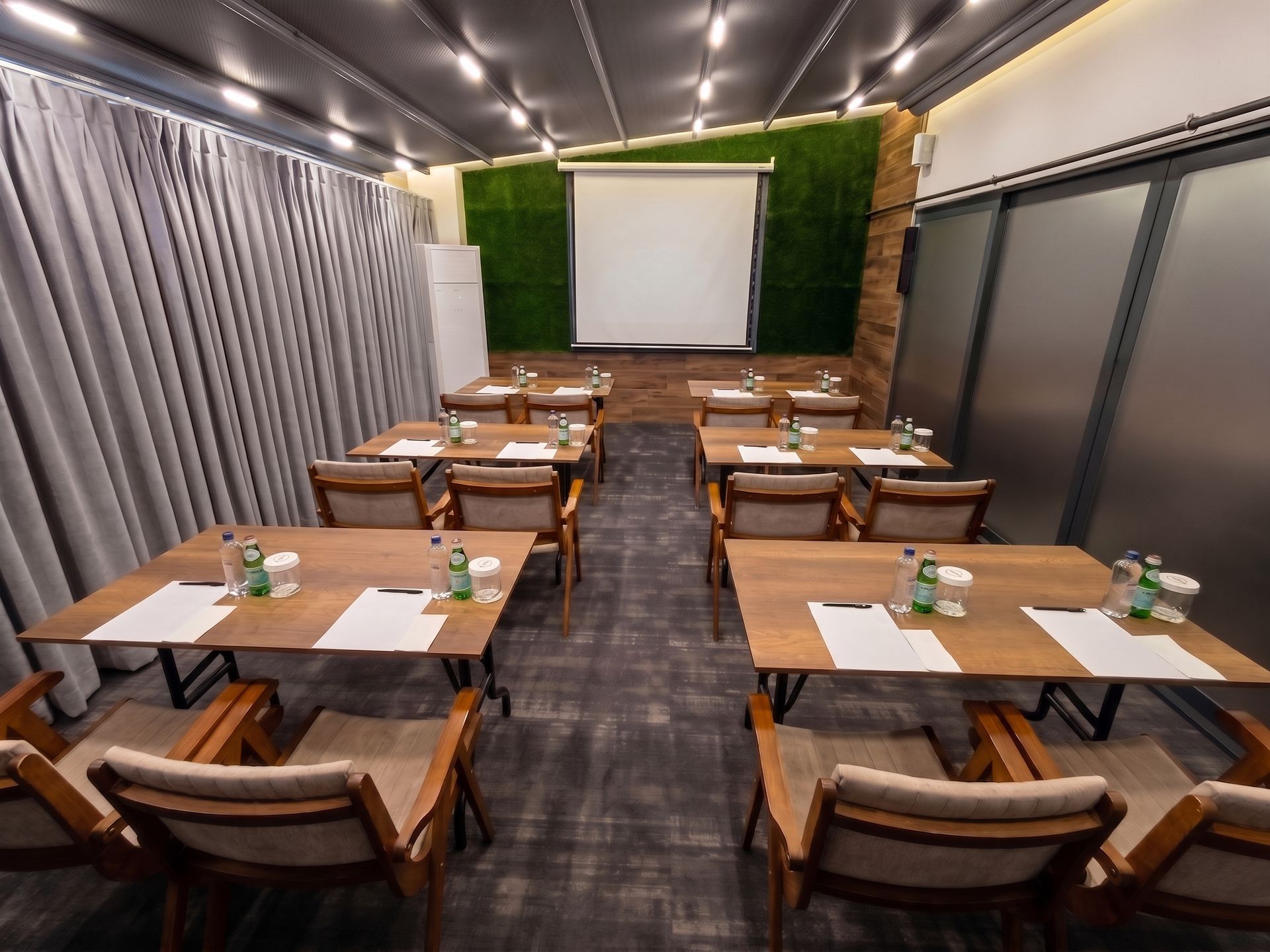 Izz Hotel Koşuyolu | İstanbul |Empty conference room with rows of tables, chairs, projector screen