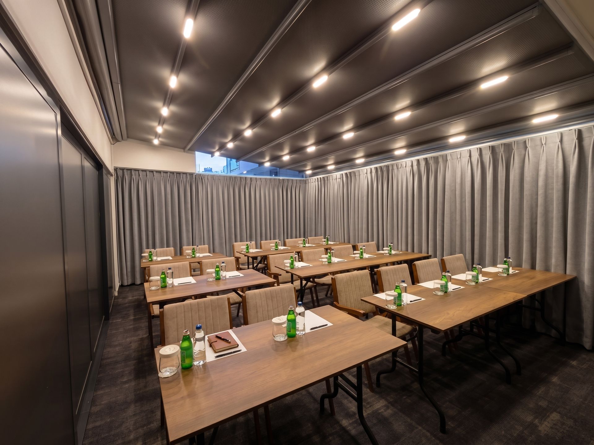 Izz Hotel Koşuyolu | İstanbul | Empty banquet room with rows of wooden tables, water bottles