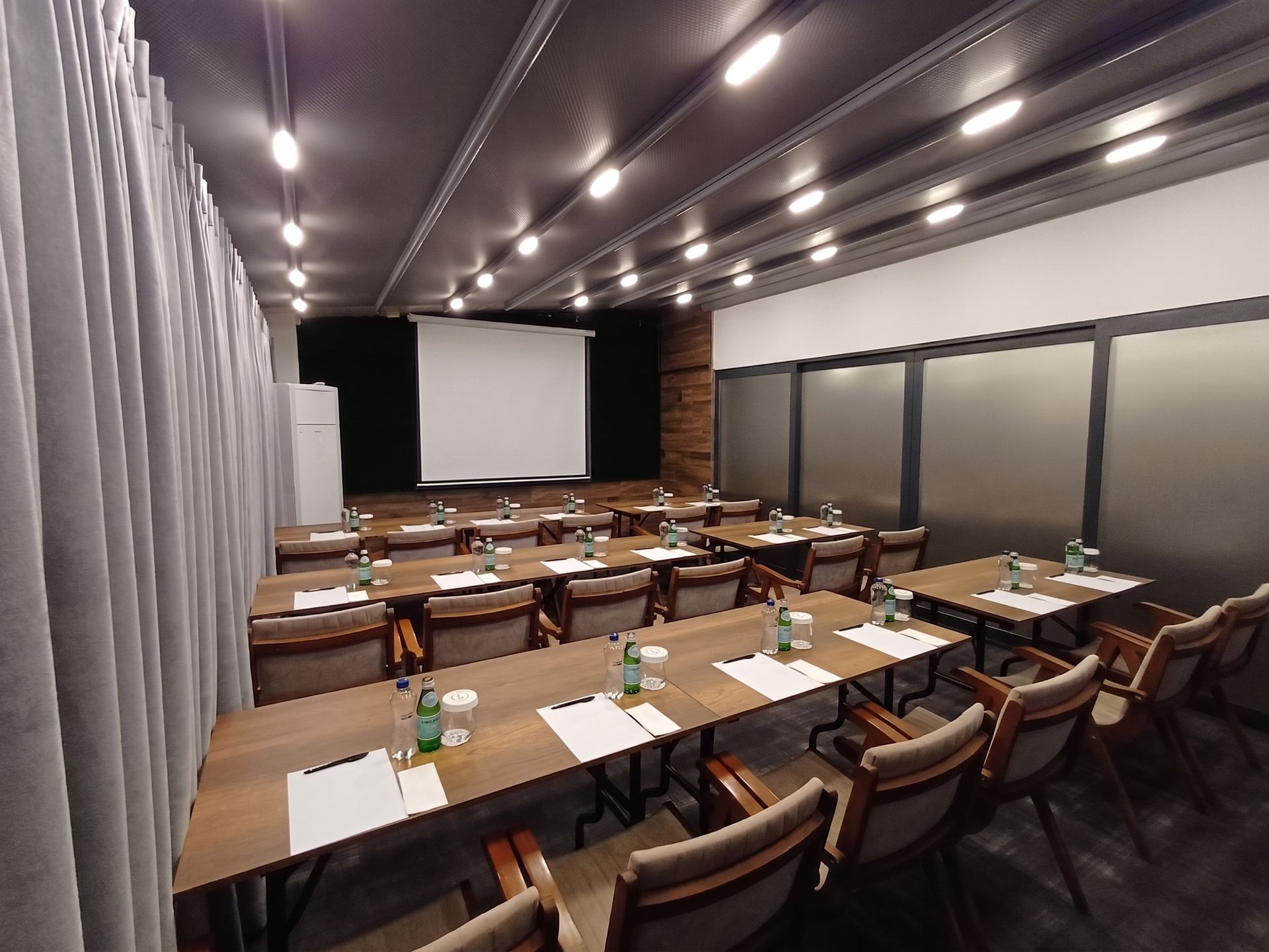 Izz Hotel Koşuyolu | İstanbul | Empty conference room with rows of desks, chairs, and a projector screen