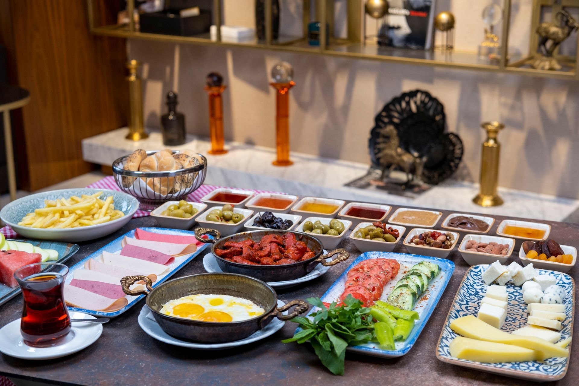 Masada yumurta, meyve, sebze, ekmek ve reçel bulunan açık büfe kahvaltı.