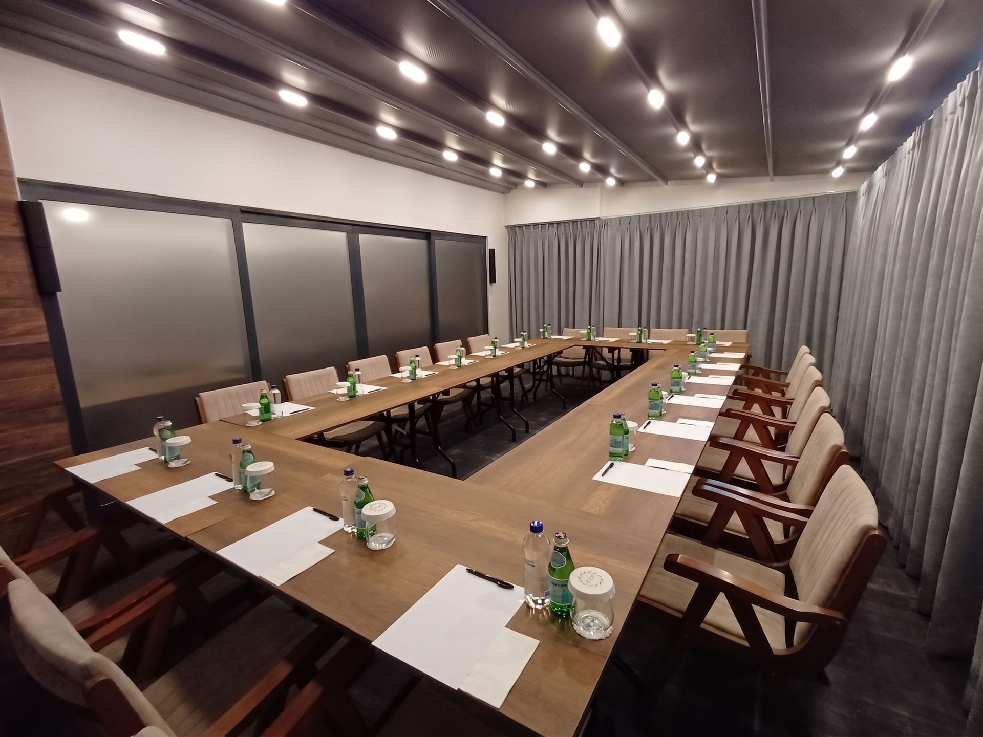 Izz Hotel Koşuyolu | İstanbul |Modern conference room with U-shaped table, beige chairs, notepads, water bottles