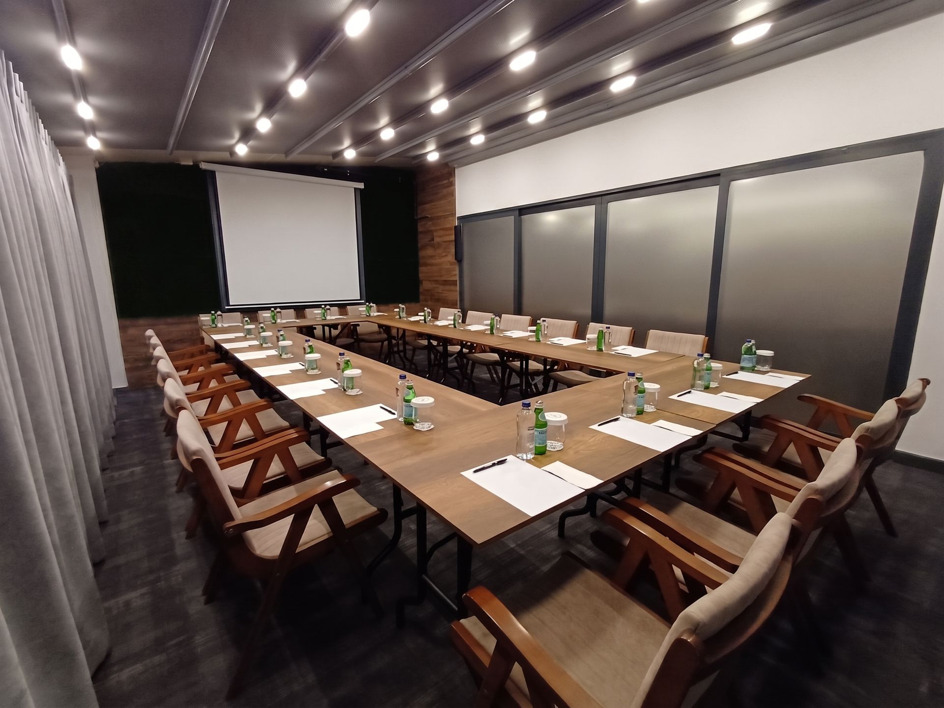Izz Hotel Koşuyolu | İstanbul |Modern conference room with U-shaped tables, chairs, and a projector screen