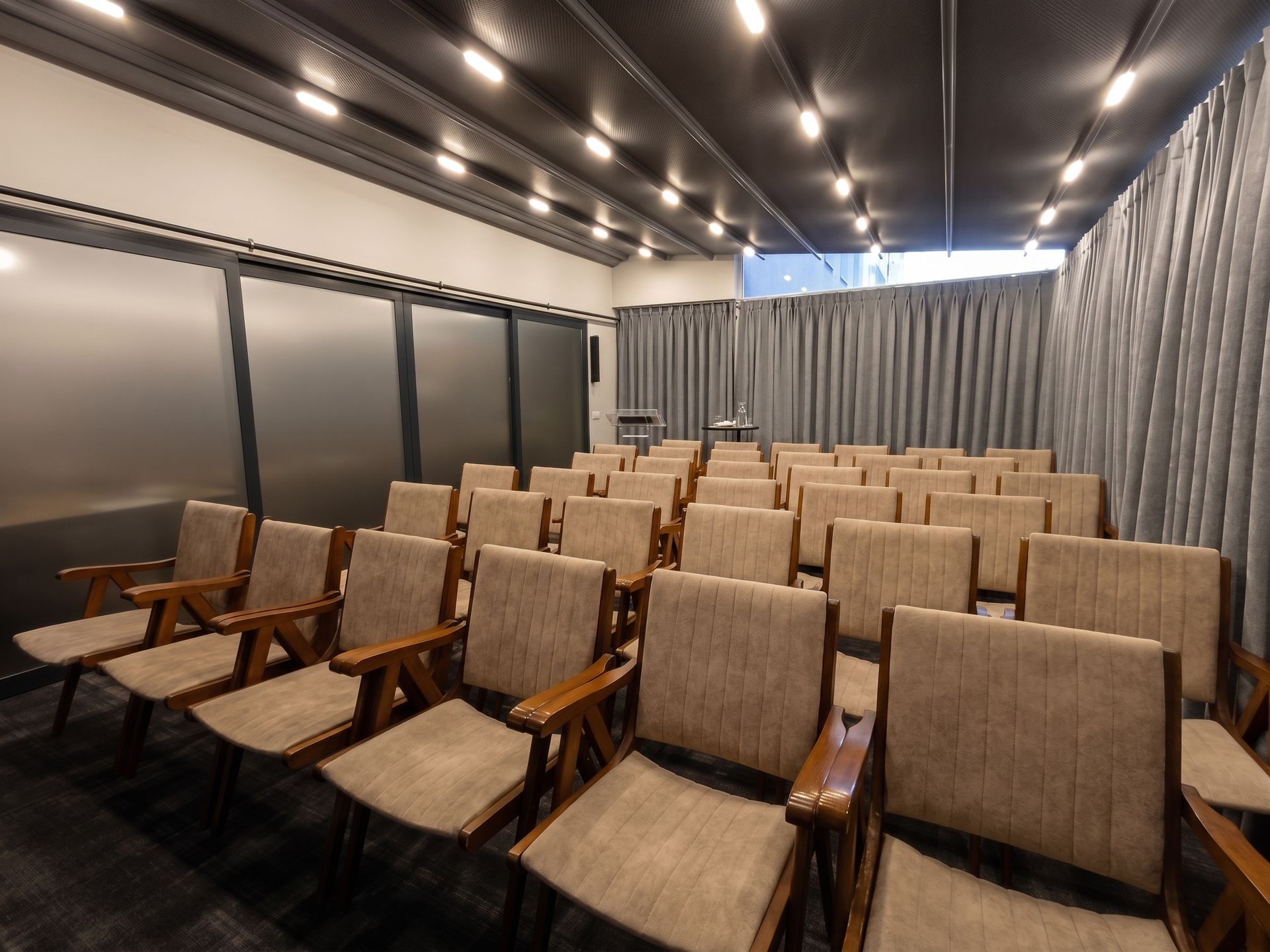 Izz Hotel Koşuyolu | İstanbul | Empty theater with rows of tan seats and warm ceiling lights