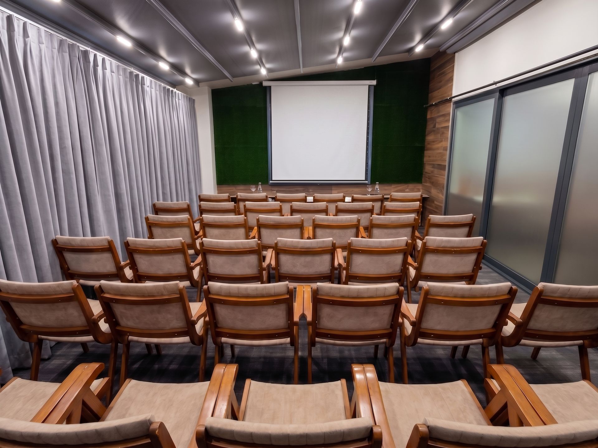 Izz Hotel Koşuyolu | İstanbul | Empty modern lecture hall with rows of wooden seats facing a projection screen
