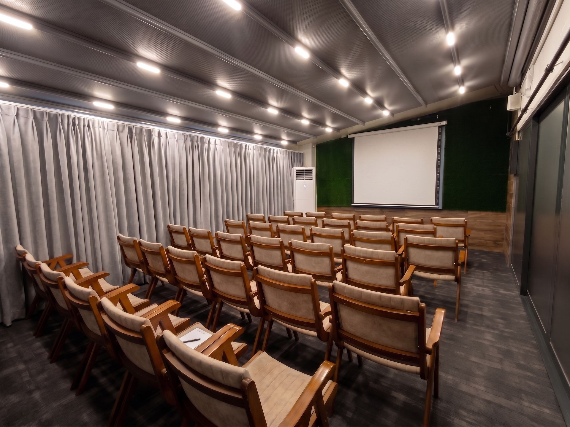 Izz Hotel Koşuyolu | İstanbul | Empty auditorium with rows of wooden seats facing a projection screen