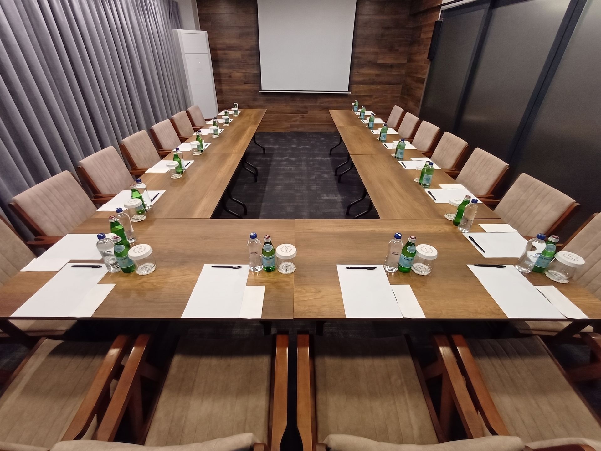 Izz Hotel Koşuyolu | İstanbul | Conference room with U-shaped wooden meeting tables, chairs, notebooks, and water bottles