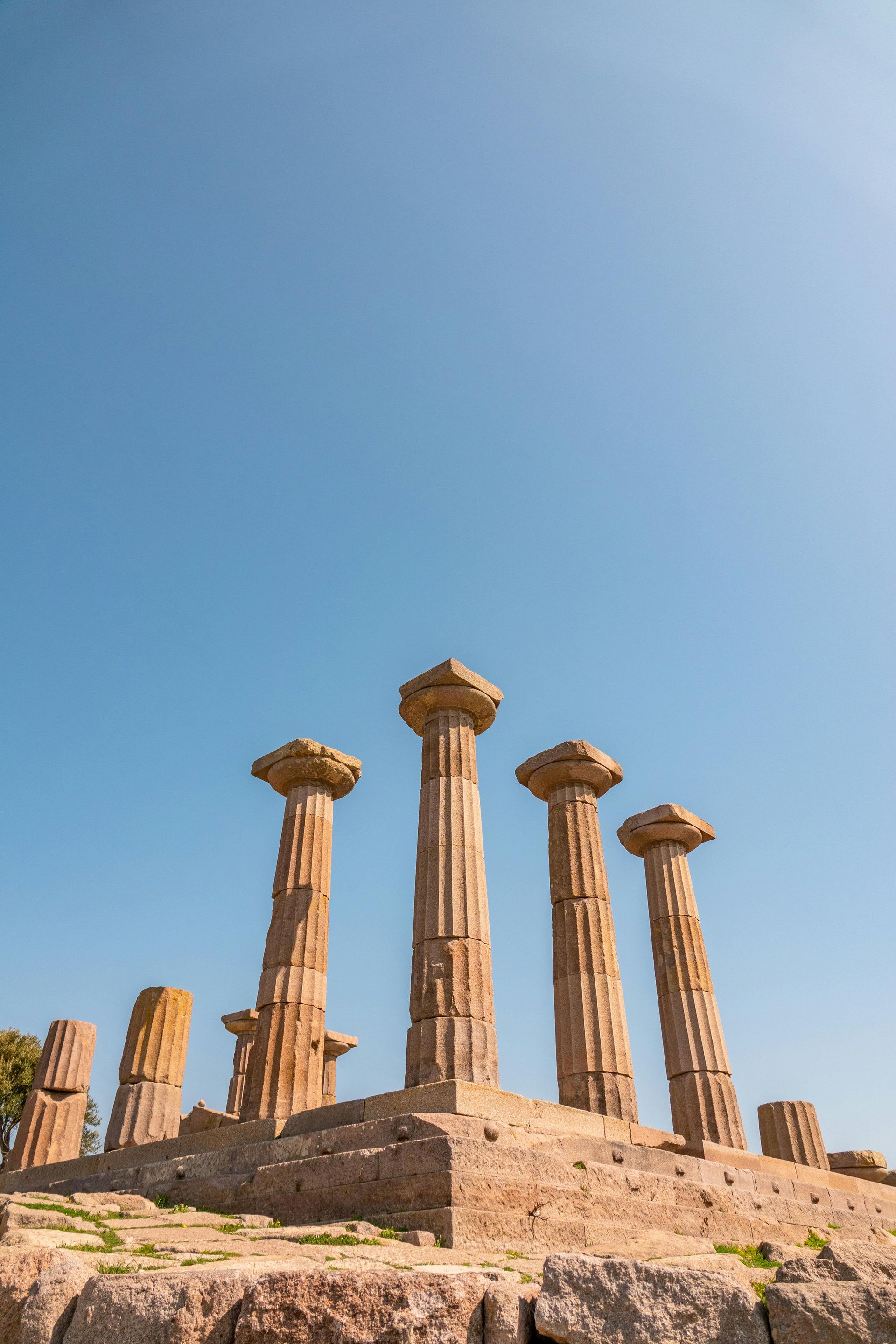 Ruins of ancient Doric columns against a blue sky.