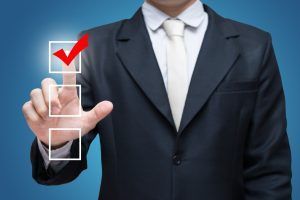 A person in a business suit selects the top box in a vertical list of three checkboxes with a red checkmark.