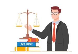 A person in a suit gesturing toward a set of scales of justice resting on a stack of law books.