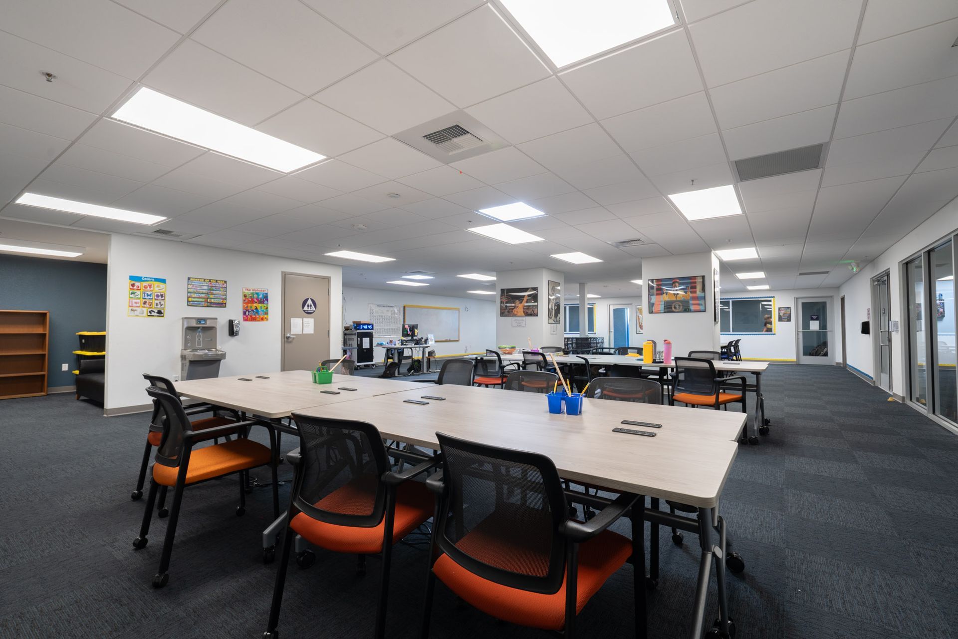 Modern open office with desks, chairs, computers, and bright ceiling lights