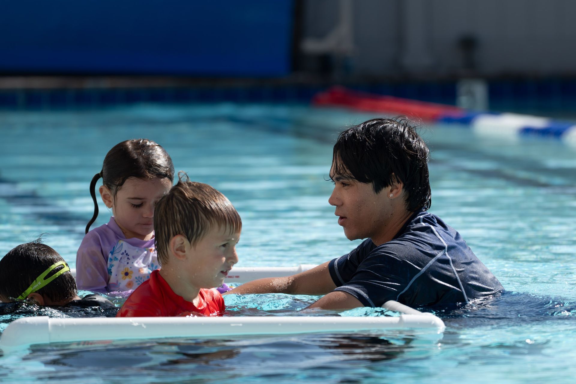 Children and an instructor in a swimming pool practicing water safety