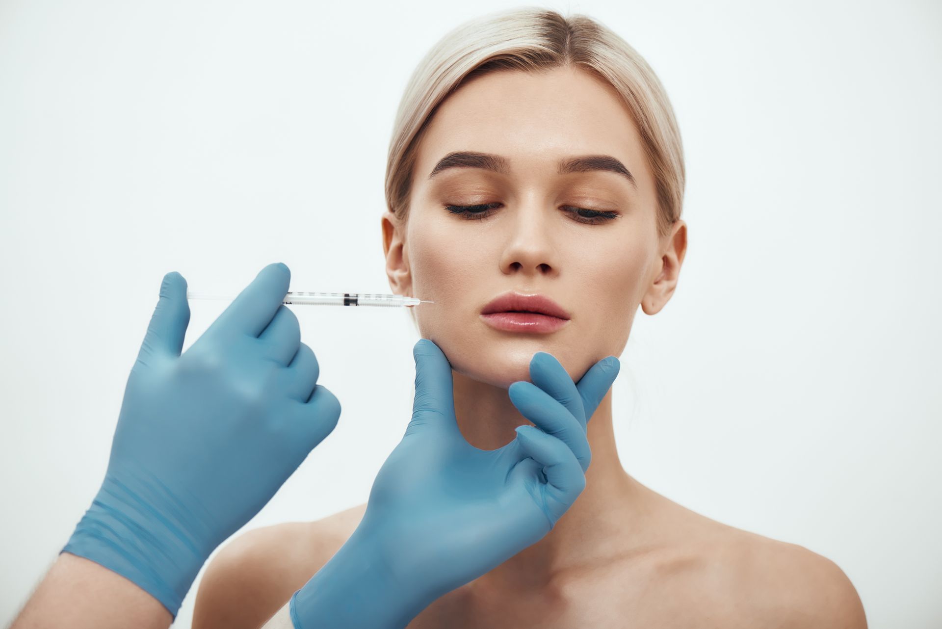 A woman is getting a botox injection in her face.