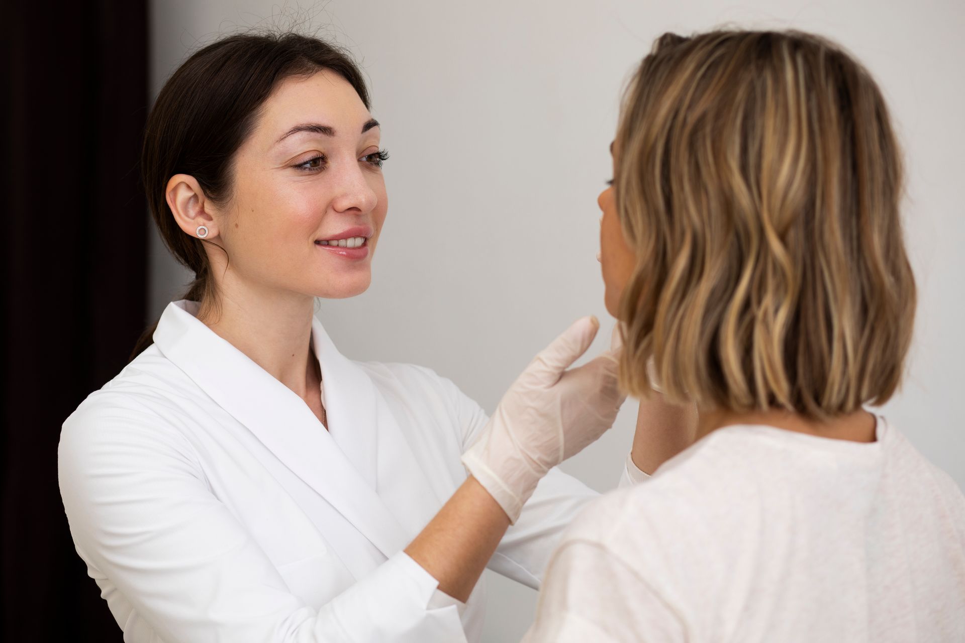 Doctor examining a patient’s neck during a medical consultation