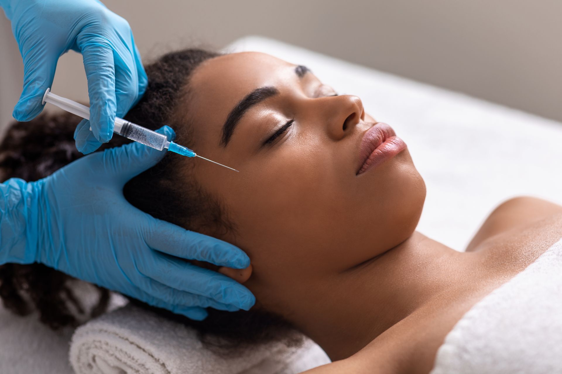 A woman is getting a botox injection in her face.