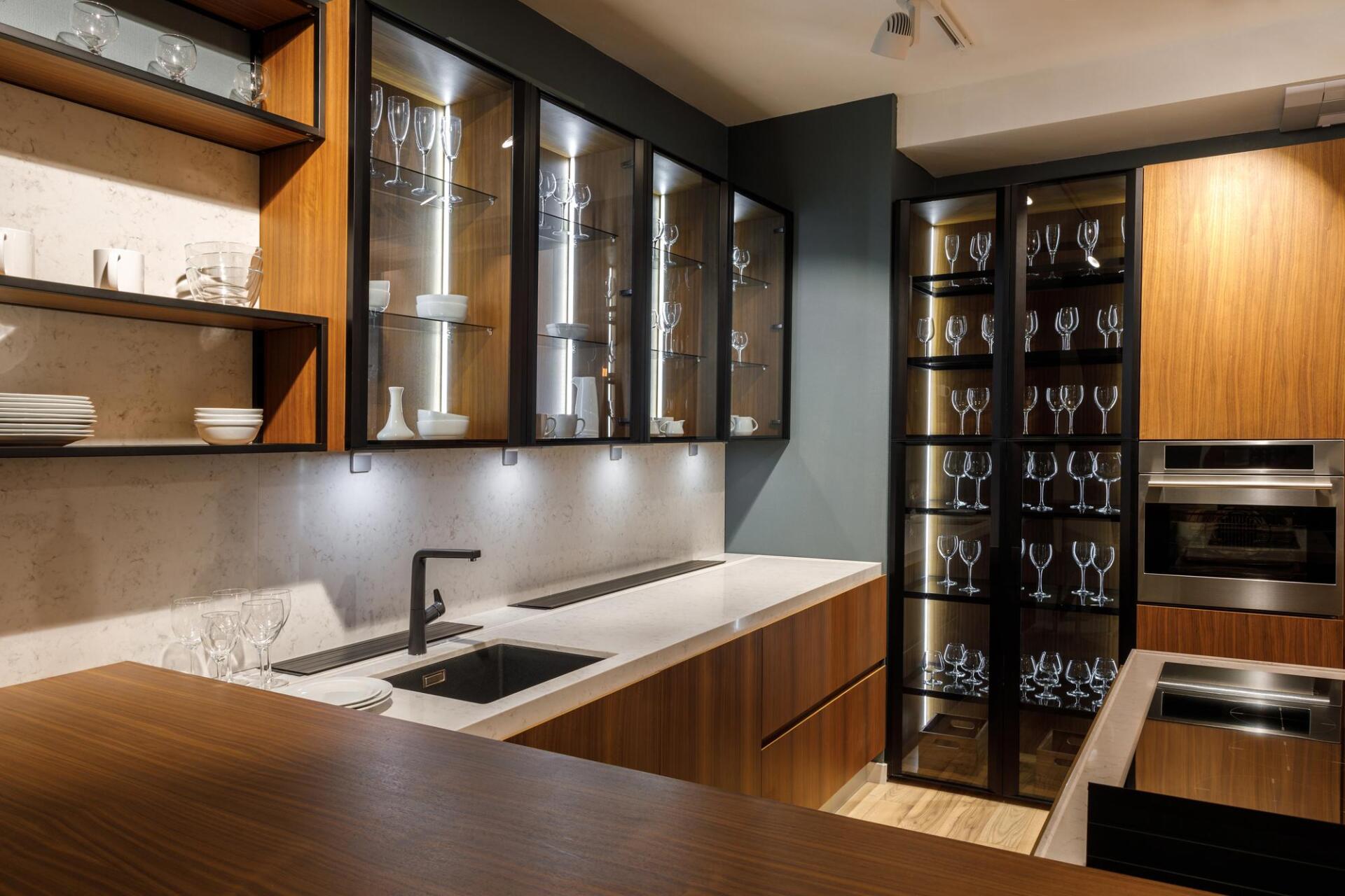 A kitchen with wooden cabinets , stainless steel appliances , a sink , and a wine cellar.