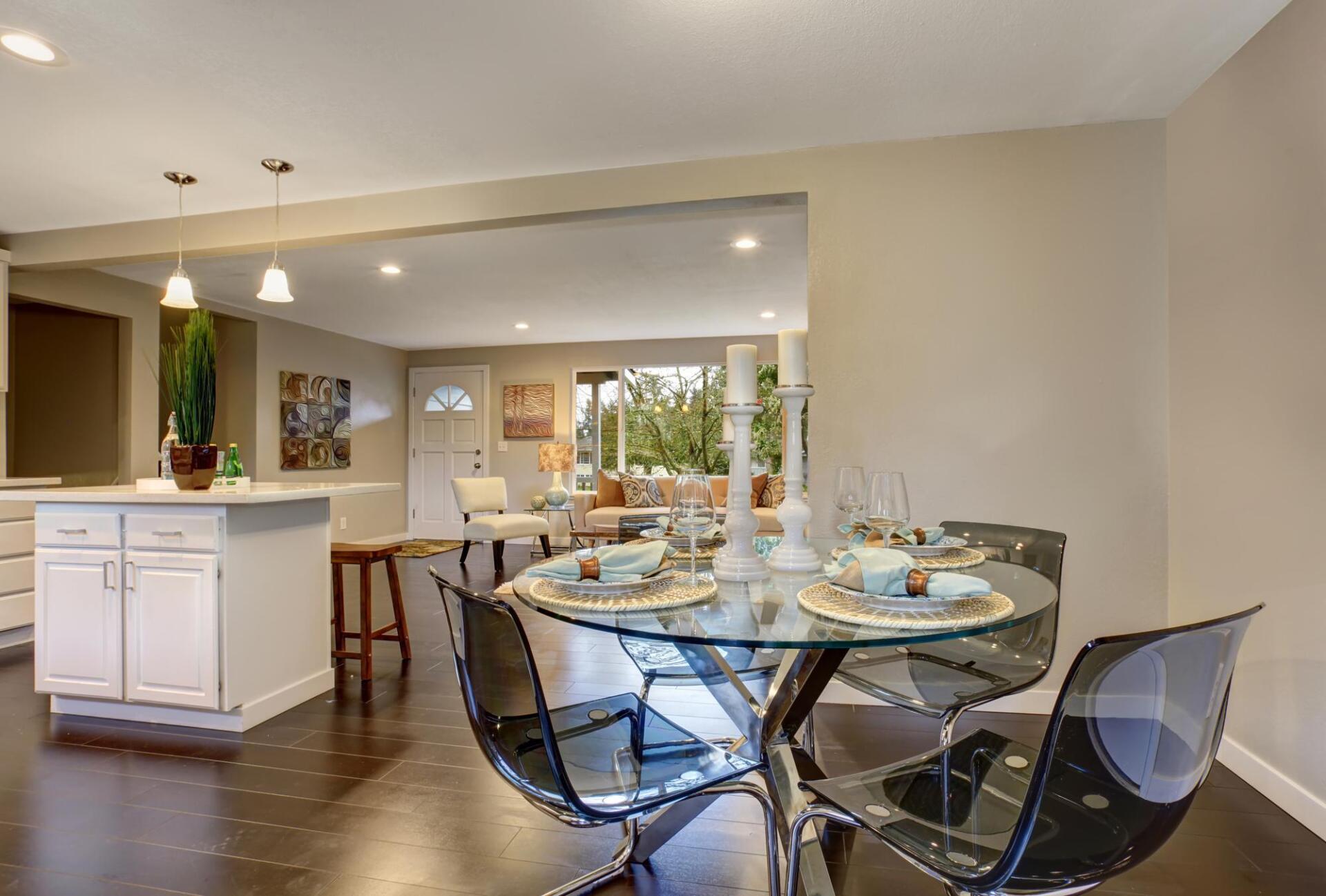 A dining room with a glass table and chairs.