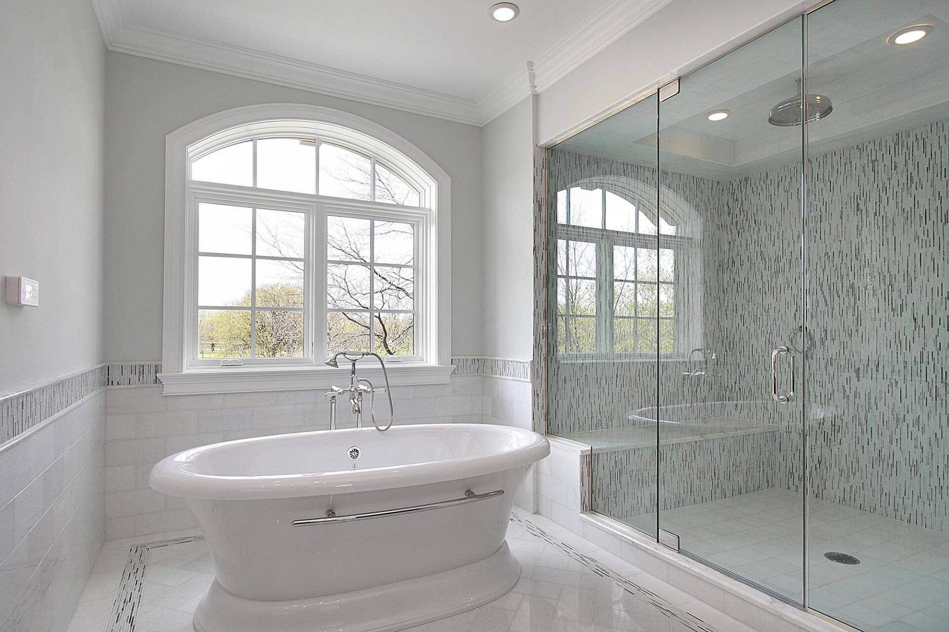 A bathroom with a tub , shower and window.