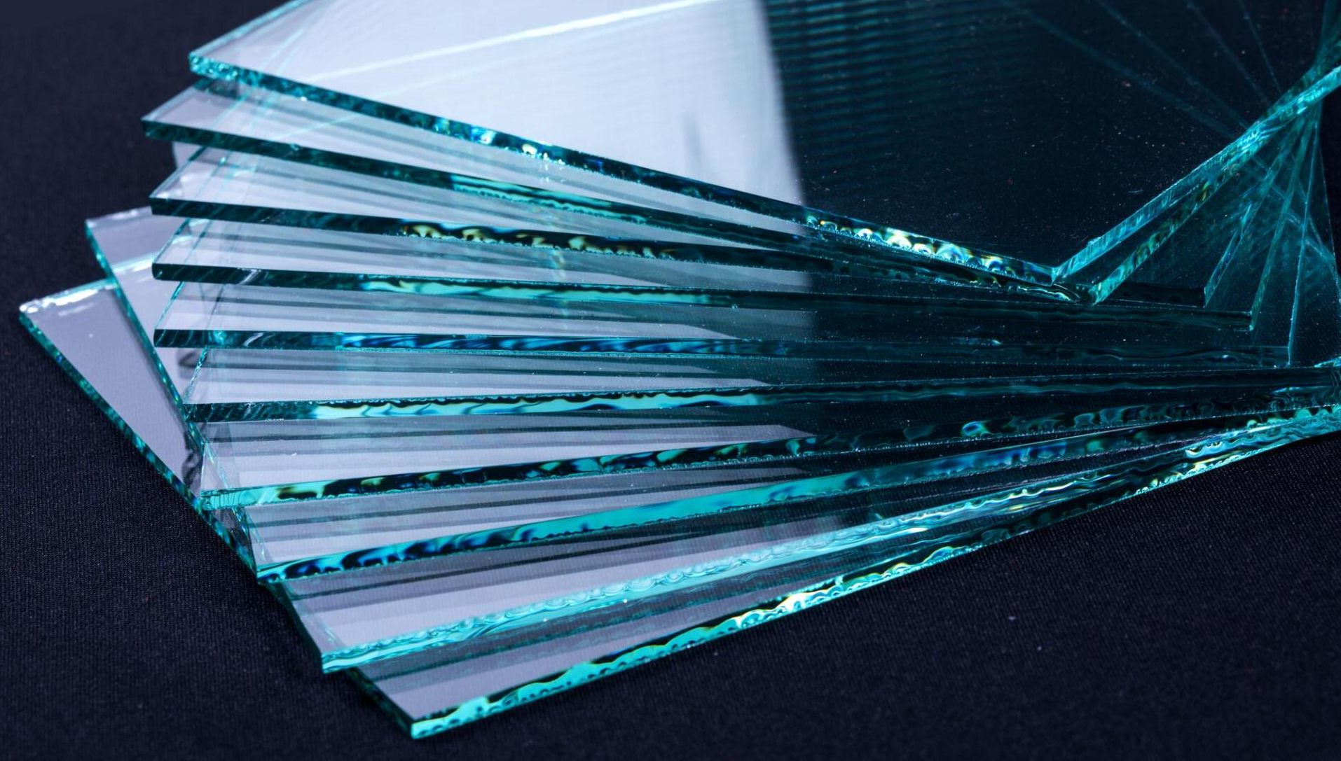 A bunch of pieces of glass are stacked on top of each other on a table.