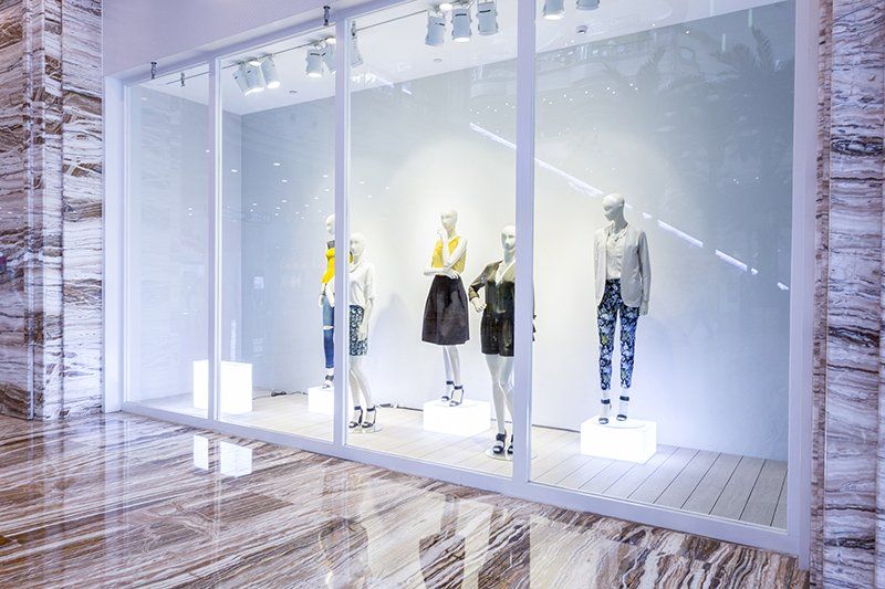 A row of mannequins in a store window.