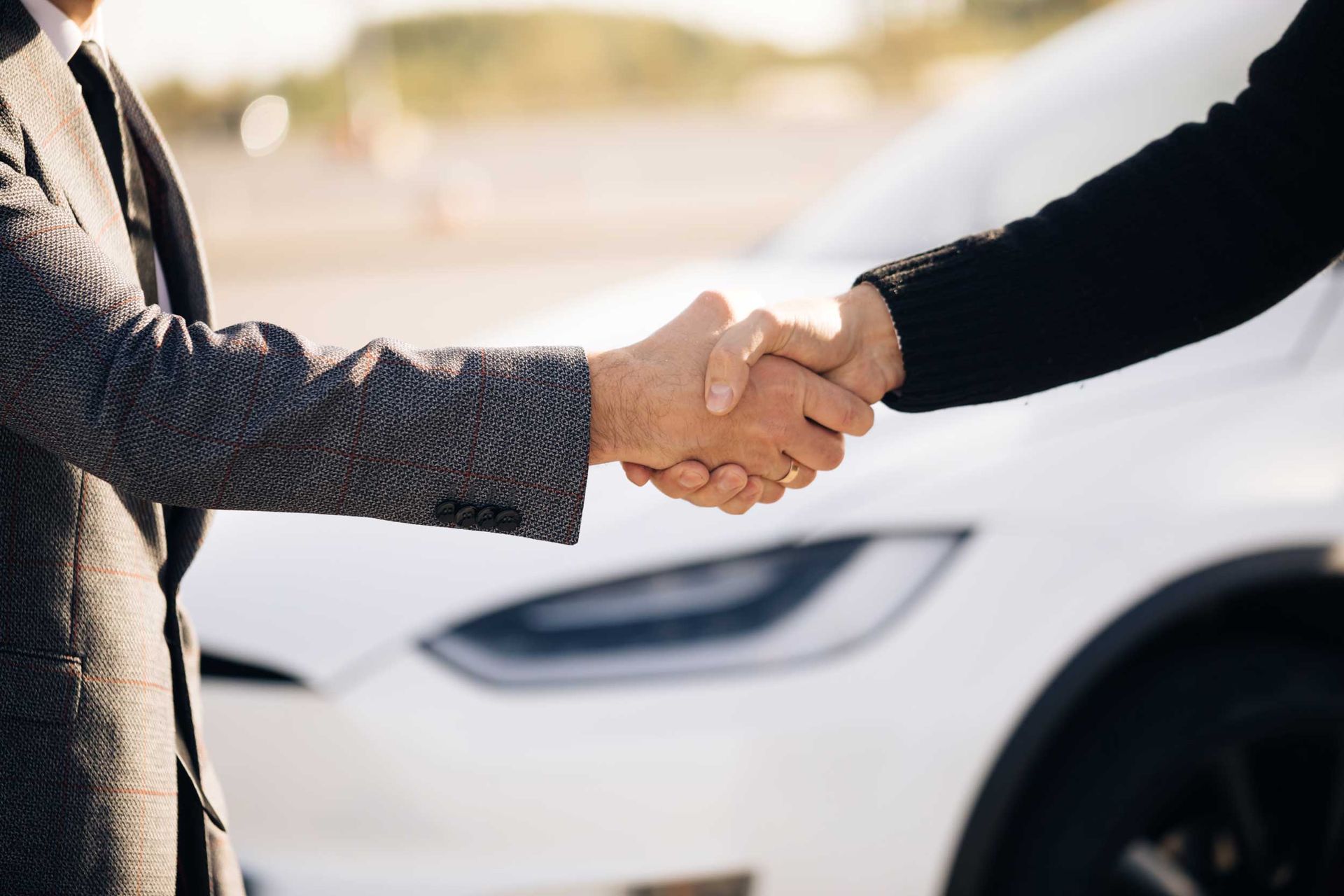 Male hand gives a car keys to male hand in the car dealership close up Male hand gives a car keys to male hand in the car dealership close up