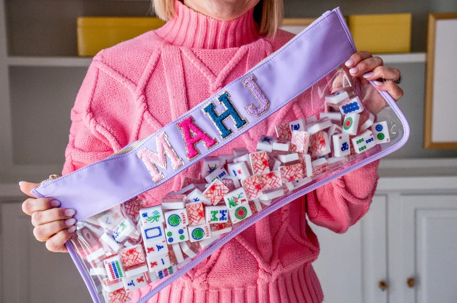 Woman holding a clear Mahjong tile bag, spelling 