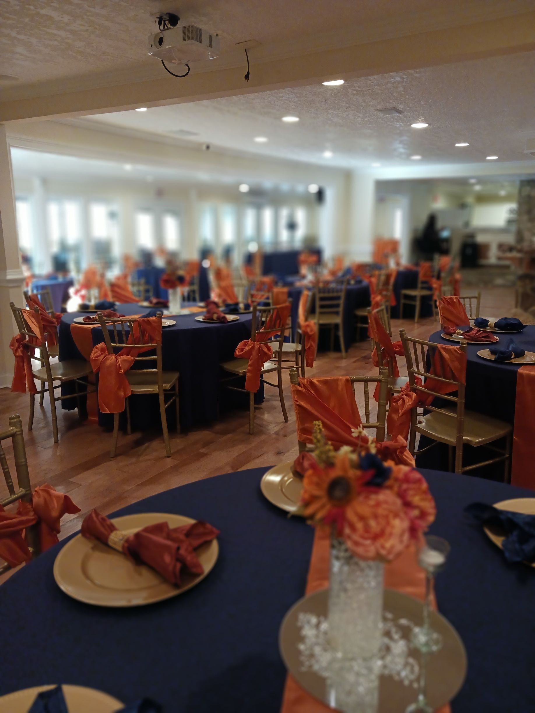 A large room with tables and chairs decorated in orange and blue