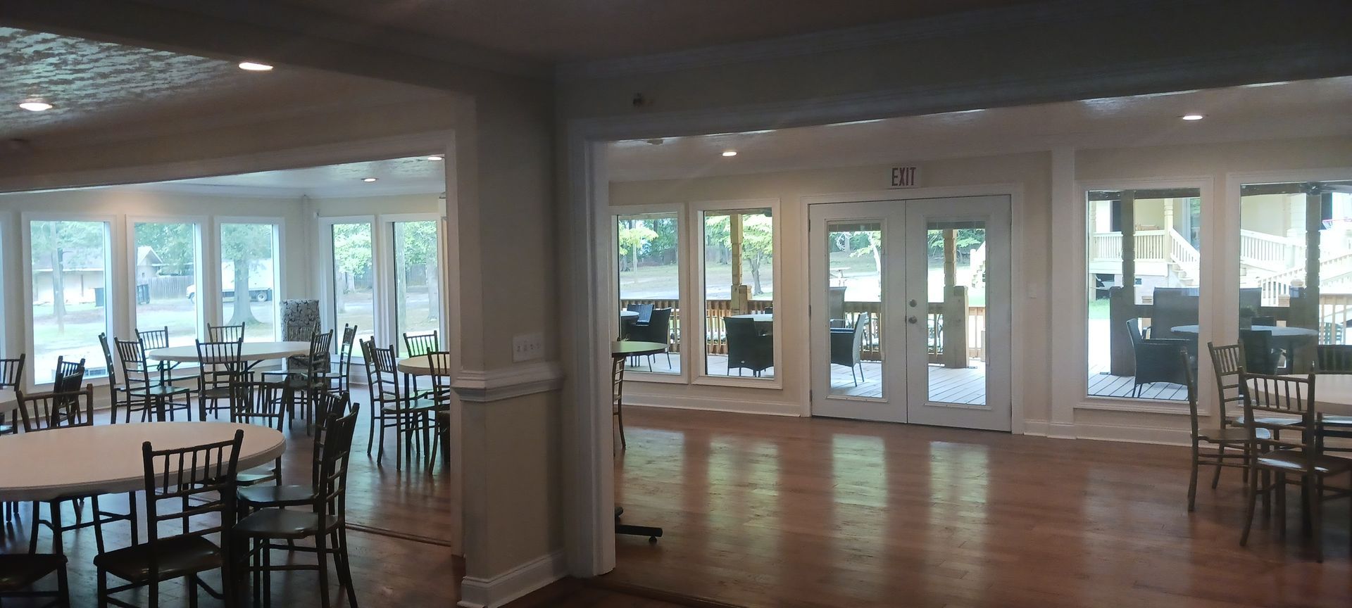 A large room with tables and chairs and lots of windows.