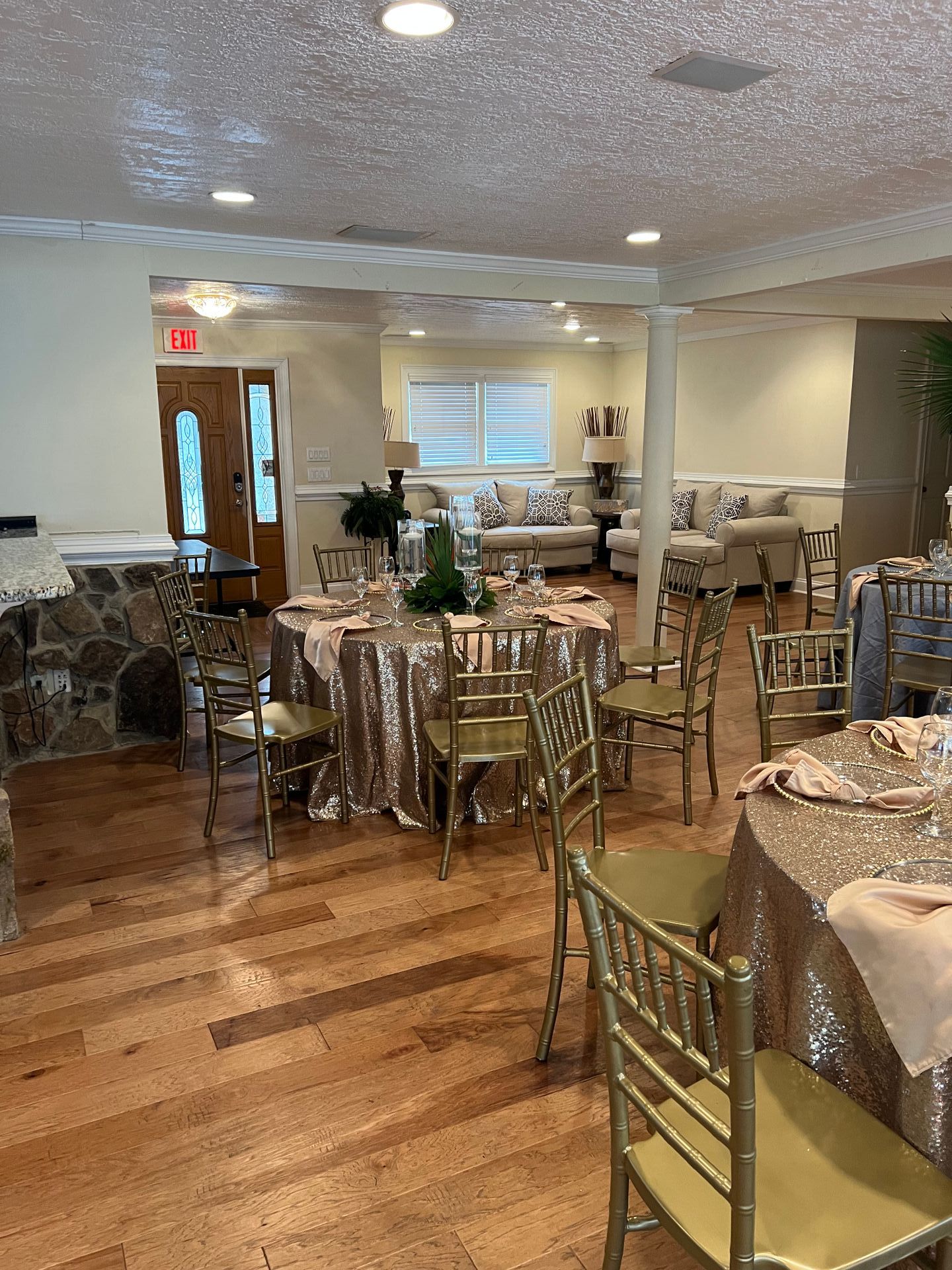 A large room with tables and chairs set up for a wedding reception.