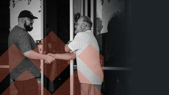 About San Antonio Christian Church Two men shaking hands outside a building, with one in a dark shirt and the other in a light shirt.