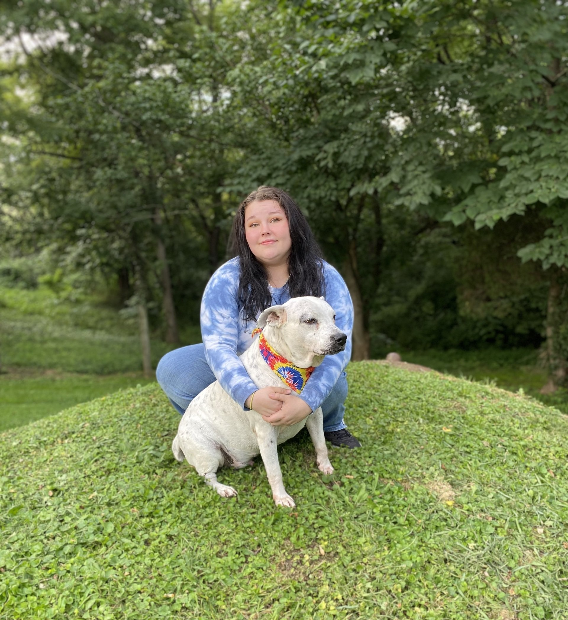 General Manager holding dog on grass